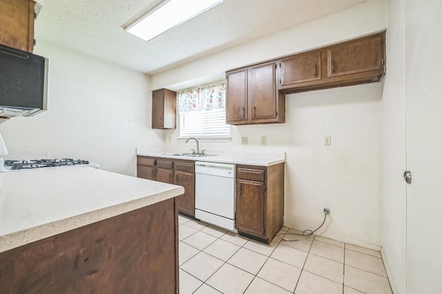 kitchen with black microwave, a sink, dishwasher, light countertops, and a textured ceiling