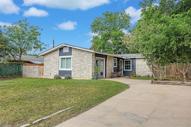 8221 Renton Dr, Austin, TX 78757 - view of front of house featuring fence, stone siding, and a front lawn