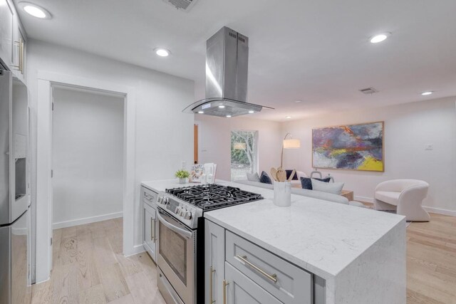 5307 Downs Dr, Austin, TX 78721 - kitchen featuring stainless steel appliances, island exhaust hood, light wood-style floors, recessed lighting, and light stone countertops
