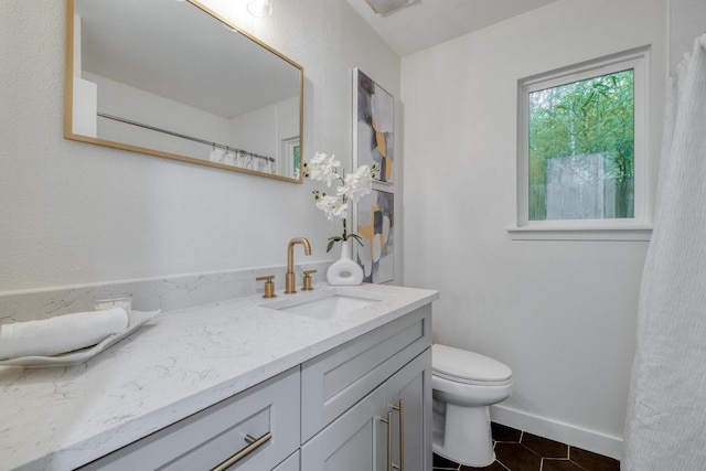 5307 Downs Dr, Austin, TX 78721 - full bathroom featuring vanity, toilet, tile patterned flooring, and baseboards