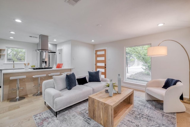 living room featuring recessed lighting, visible vents, and light wood-style floors