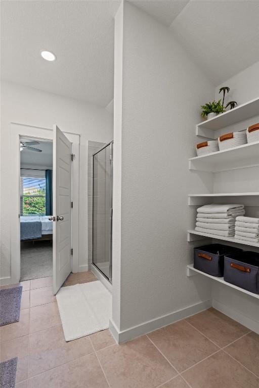 ensuite bathroom with tile patterned flooring, ensuite bathroom, baseboards, recessed lighting, and a stall shower