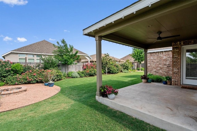 view of yard with a patio, fence, and a ceiling fan