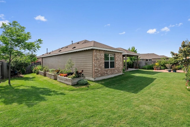 back of house featuring a fenced backyard, a lawn, and brick siding