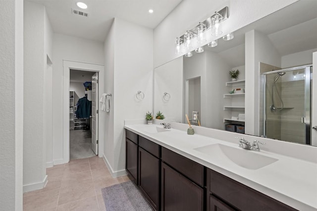 full bathroom with visible vents, a sink, a spacious closet, and a stall shower