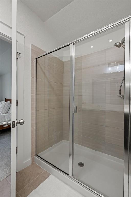 full bath featuring ensuite bathroom, tile patterned floors, and a shower stall