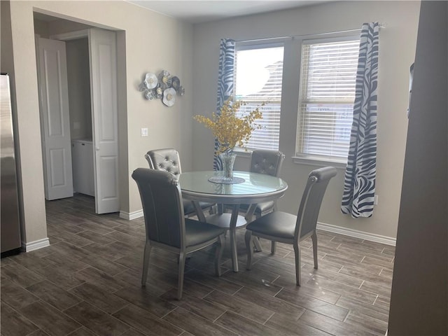 dining area with baseboards and dark wood-type flooring