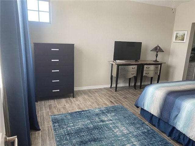 bedroom featuring baseboards and wood tiled floor