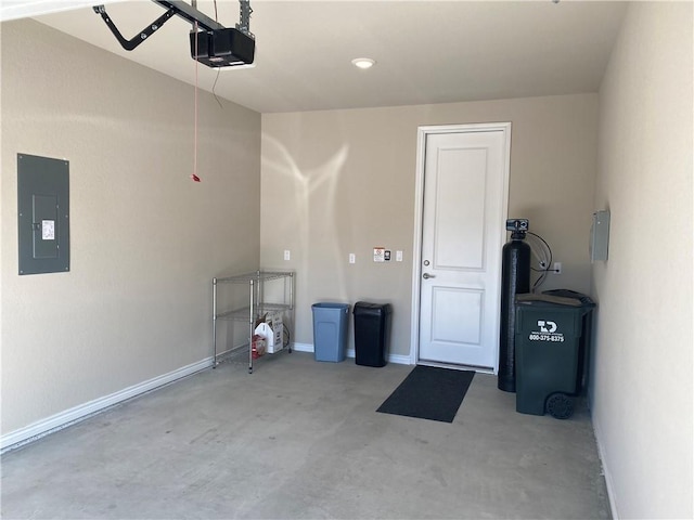garage featuring baseboards, a garage door opener, and electric panel