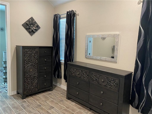 bedroom featuring baseboards and wood finish floors