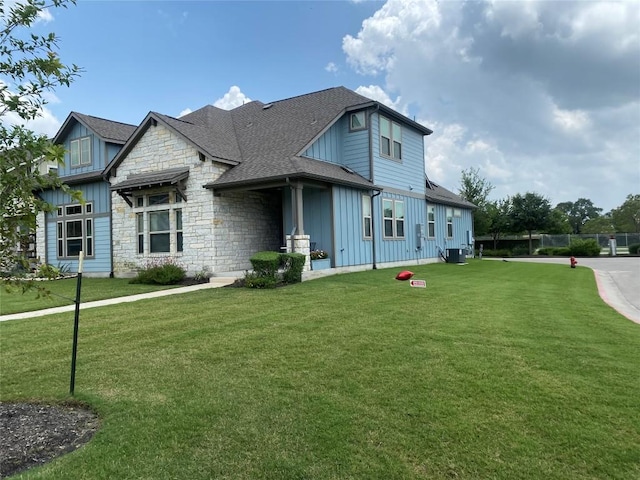 117 Bolivar Way Unit 101, San Marcos, TX 78666 - view of front of house featuring board and batten siding, a front yard, stone siding, and roof with shingles