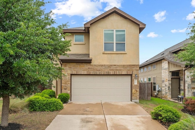 view of front of house with fence, an attached garage, stone siding, stucco siding, and concrete driveway