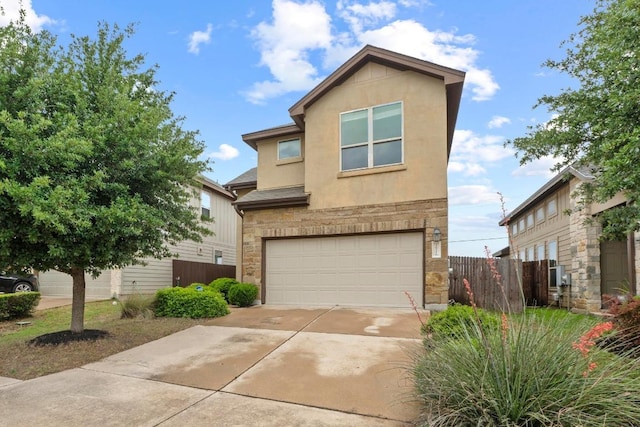 traditional-style home featuring fence, stone siding, stucco siding, an attached garage, and driveway