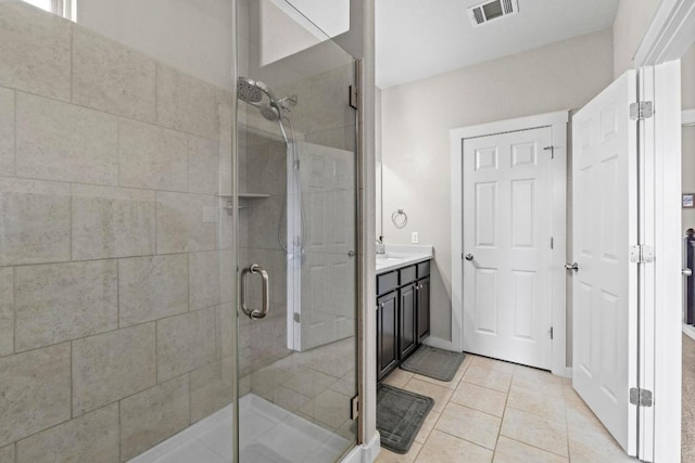 bathroom featuring tile patterned flooring, a stall shower, and visible vents