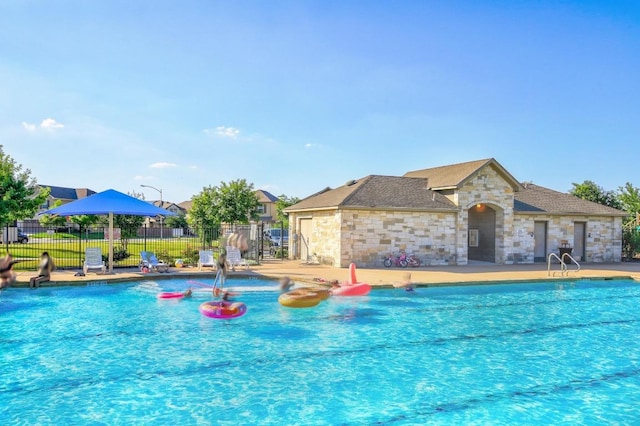 community pool featuring a patio and fence