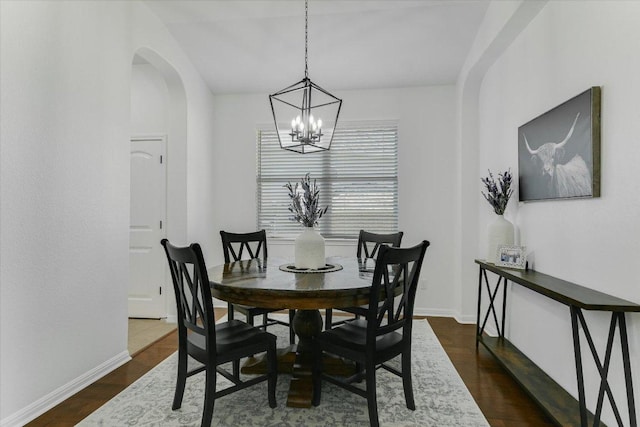 240 Fort Mabry Loop, Georgetown, TX 78628 - dining area with arched walkways, baseboards, an inviting chandelier, and dark wood-type flooring