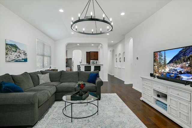 240 Fort Mabry Loop, Georgetown, TX 78628 - living room with arched walkways, baseboards, dark wood-style floors, an inviting chandelier, and recessed lighting
