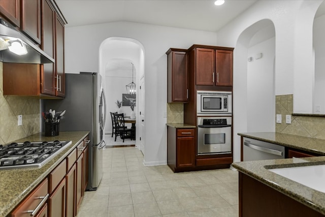 240 Fort Mabry Loop, Georgetown, TX 78628 - kitchen featuring appliances with stainless steel finishes, under cabinet range hood, arched walkways, and reddish brown cabinets