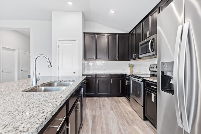 216 Pearland St, Hutto, TX 78634 - kitchen featuring a sink, appliances with stainless steel finishes, light stone countertops, and lofted ceiling