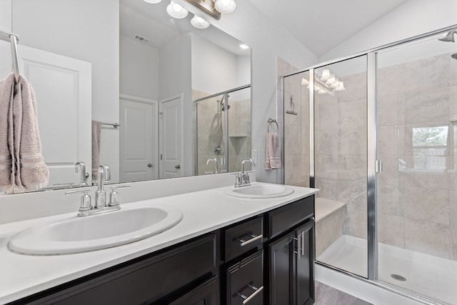216 Pearland St, Hutto, TX 78634 - full bath with a sink, visible vents, double vanity, a shower stall, and vaulted ceiling