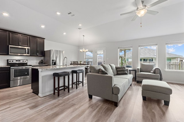 216 Pearland St, Hutto, TX 78634 - living area with visible vents, recessed lighting, light wood-type flooring, ceiling fan with notable chandelier, and vaulted ceiling