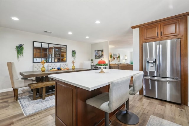 2858 Cedar Hollow Rd, Georgetown, TX 78628 - kitchen featuring stainless steel fridge with ice dispenser, light wood-style flooring, a center island, recessed lighting, and light countertops
