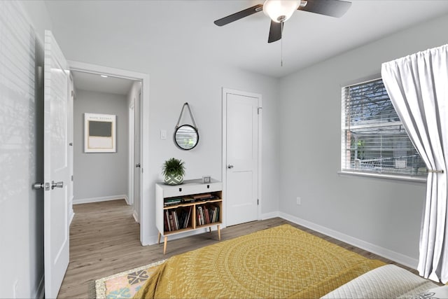 bedroom with baseboards, a ceiling fan, and wood finished floors