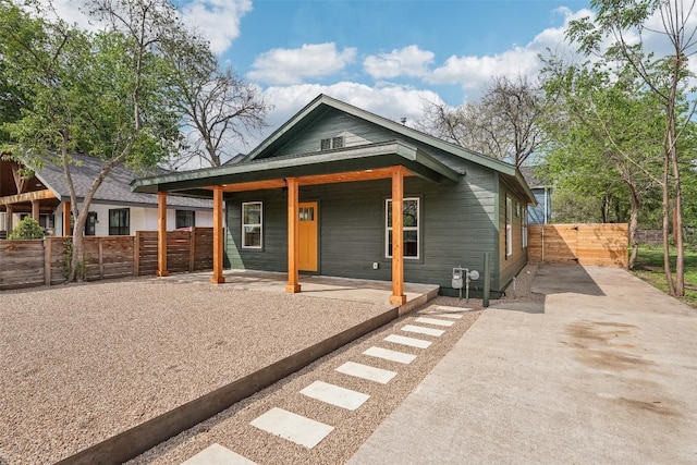 view of front of property with fence, covered porch, and driveway