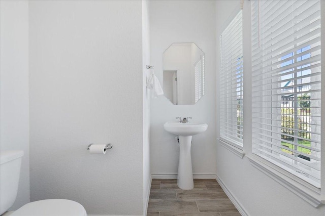 9015 Looksee Ln, Austin, TX 78744 - half bathroom featuring toilet, baseboards, and wood finished floors