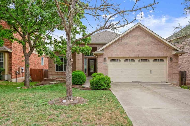 view of front of property with an attached garage, concrete driveway, brick siding, and a front yard