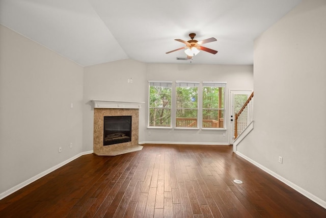 unfurnished living room featuring a ceiling fan, a high end fireplace, dark wood finished floors, baseboards, and stairs