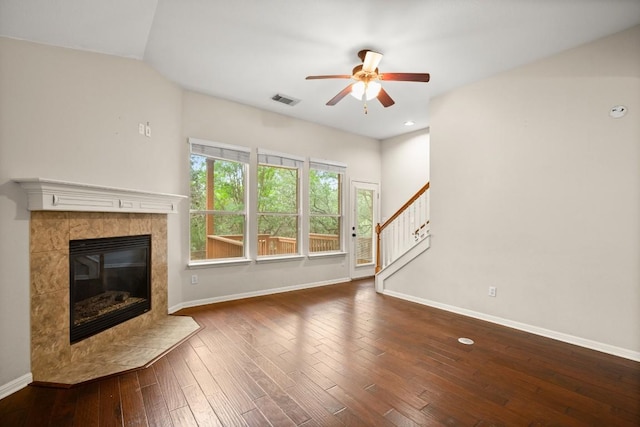 unfurnished living room with ceiling fan, baseboards, a high end fireplace, visible vents, and stairway