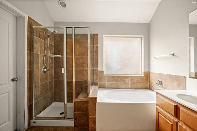 full bath featuring a garden tub, lofted ceiling, a stall shower, and vanity