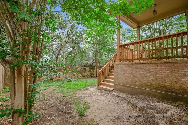 view of yard featuring fence and stairs