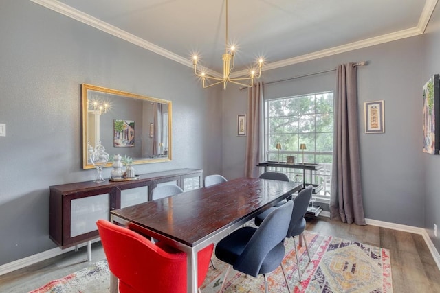 dining space with an inviting chandelier, baseboards, ornamental molding, and wood finished floors