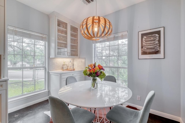 dining space with baseboards, visible vents, and a notable chandelier