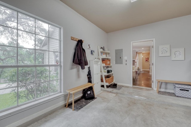 mudroom with baseboards, concrete floors, and electric panel