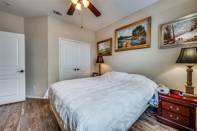 bedroom featuring a ceiling fan, visible vents, wood finished floors, baseboards, and a closet