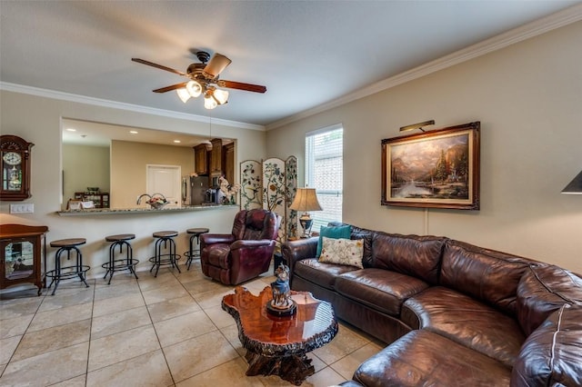 living room with crown molding, light tile patterned floors, and ceiling fan