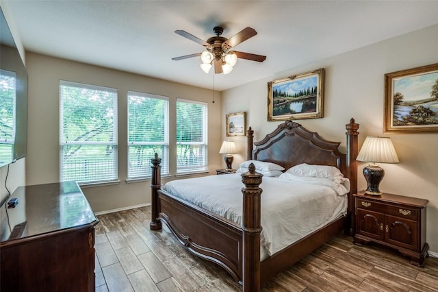 bedroom with baseboards, a ceiling fan, dark wood finished floors, and multiple windows