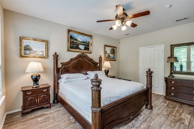 bedroom featuring a ceiling fan, visible vents, and light wood-style floors