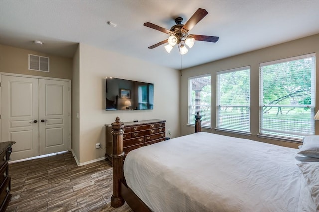 bedroom featuring baseboards, visible vents, dark wood-style floors, and ceiling fan