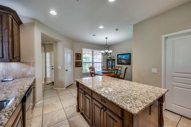 kitchen with decorative backsplash, visible vents, a center island, dishwasher, and an inviting chandelier