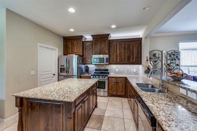 kitchen featuring appliances with stainless steel finishes, tasteful backsplash, light stone countertops, a sink, and light tile patterned floors
