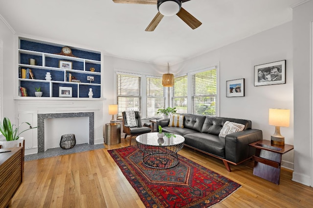 5011 Eilers Ave, Austin, TX 78751 - living area featuring hardwood / wood-style floors, a ceiling fan, ornamental molding, a fireplace, and baseboards