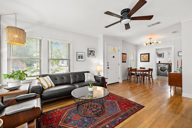 5011 Eilers Ave, Austin, TX 78751 - living area featuring washer / clothes dryer, a chandelier, a ceiling fan, light wood finished floors, and crown molding