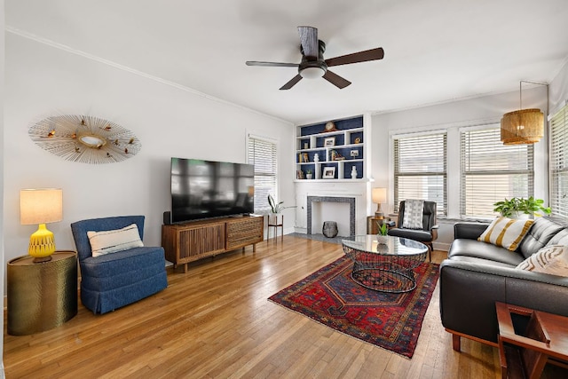 5011 Eilers Ave, Austin, TX 78751 - living area with wood-type flooring, ceiling fan, a fireplace, and ornamental molding