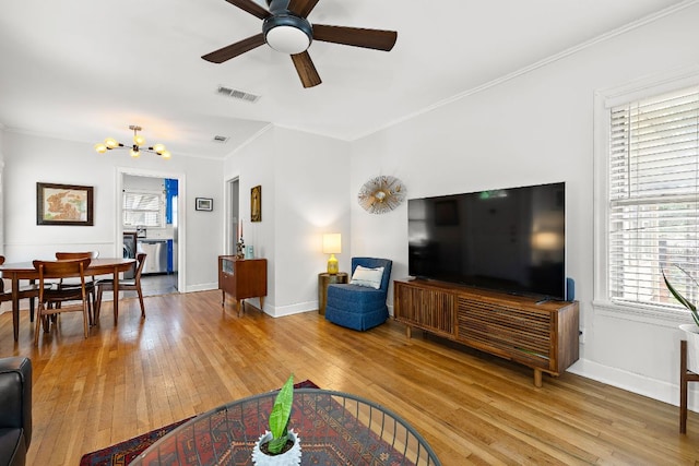 5011 Eilers Ave, Austin, TX 78751 - living area with light wood-style flooring, a ceiling fan, baseboards, a chandelier, and crown molding