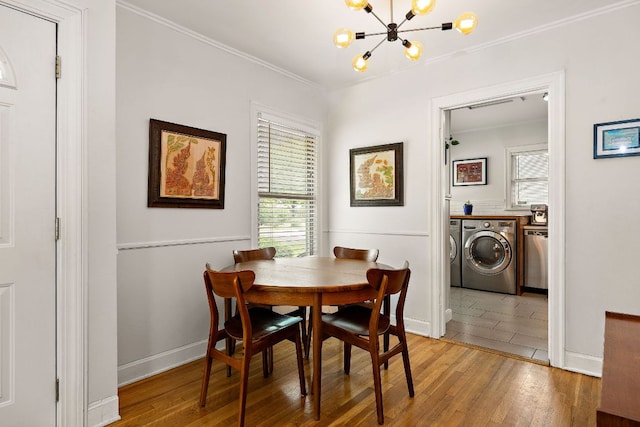 5011 Eilers Ave, Austin, TX 78751 - dining area featuring washing machine and dryer, wood finished floors, a chandelier, ornamental molding, and baseboards