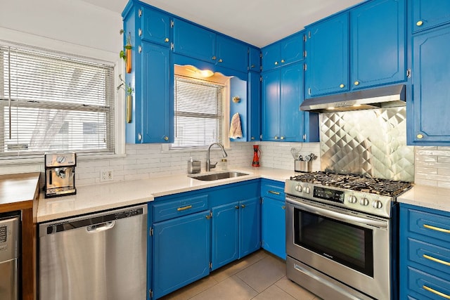5011 Eilers Ave, Austin, TX 78751 - kitchen with stainless steel appliances, a sink, under cabinet range hood, light tile patterned floors, and backsplash